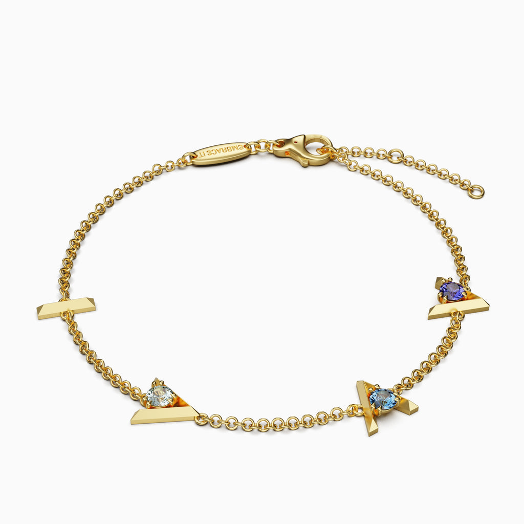 18 karat Gold bracelet with “I am greater than my highs and lows” charms and three different blue gemstones.