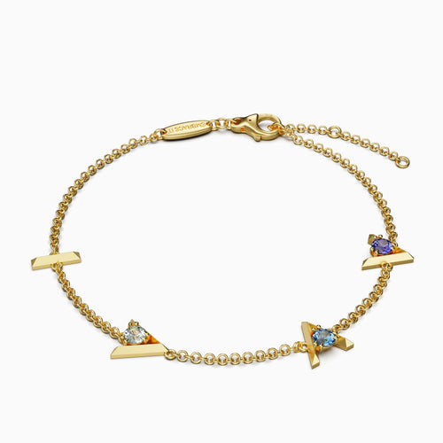 18 karat Gold bracelet with “I am greater than my highs and lows” charms and three different blue gemstones.