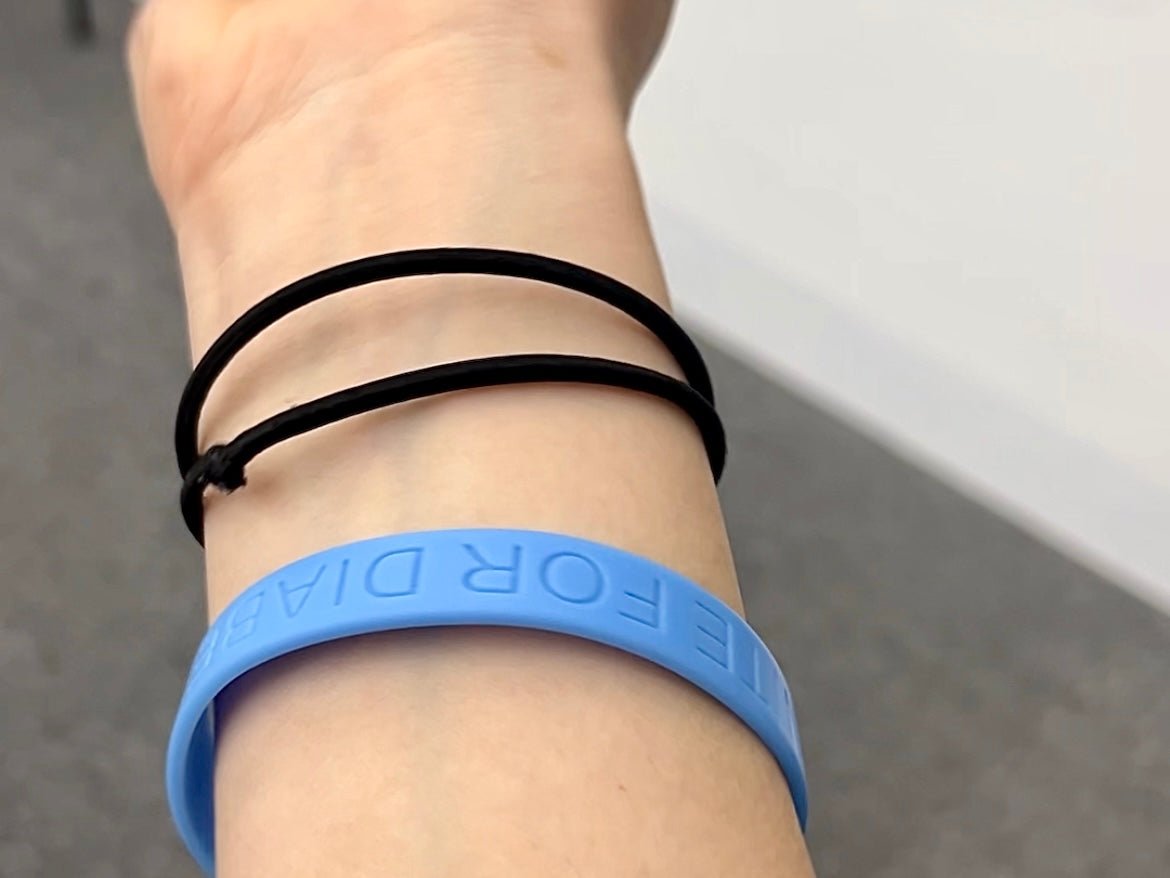 Blue wristband with the text "Unite for Diabetes" on a wrist against a neutral background